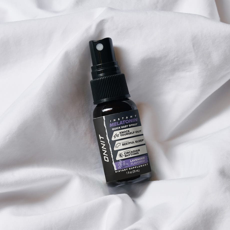 bottle of lavender flavored melatonin on a white bedsheet